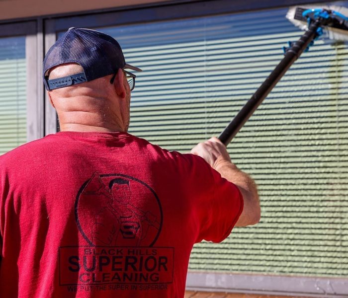Jon the Window Cleaning Expert cleaning an office window.